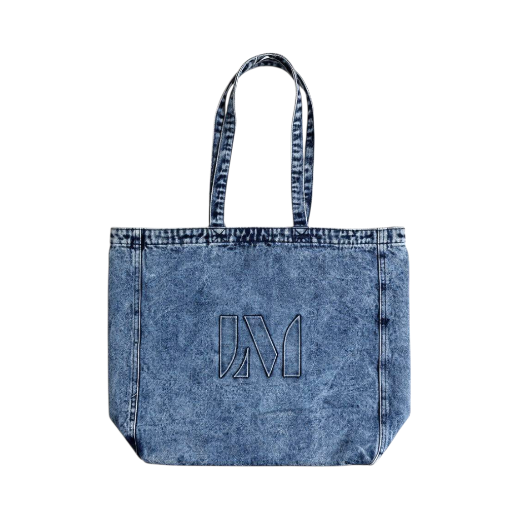 A blue acid-wash denim tote bag with a large outlined 'Lucas Museum' logo on the front, set against a plain white background.