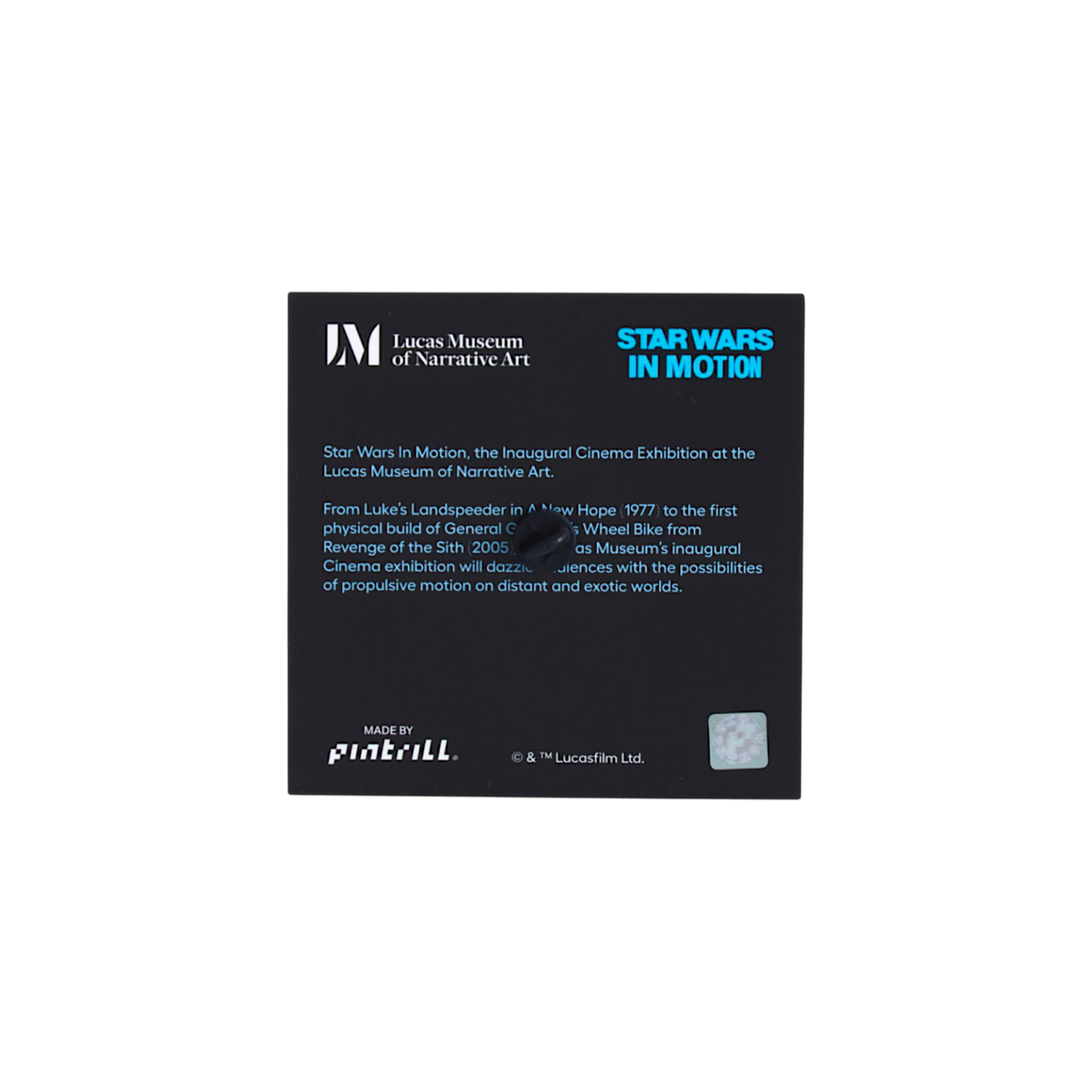 A black rectangular product tag with white and bright blue text, photographed centered on a plain white background. Visible text includes 'Lucas Museum of Narrative Art,' 'STAR WARS IN MOTION.'