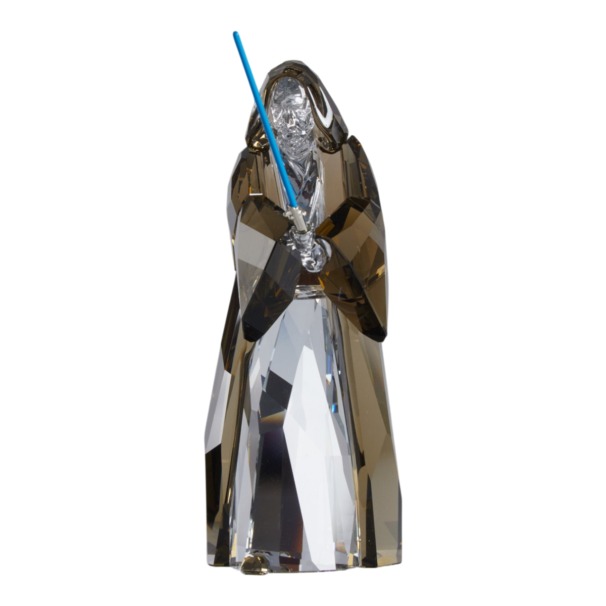 A clear faceted Swarovski crystal figurine of Obi-Wan Kenobi holding a blue lightsaber, standing on a transparent base against a plain white background.