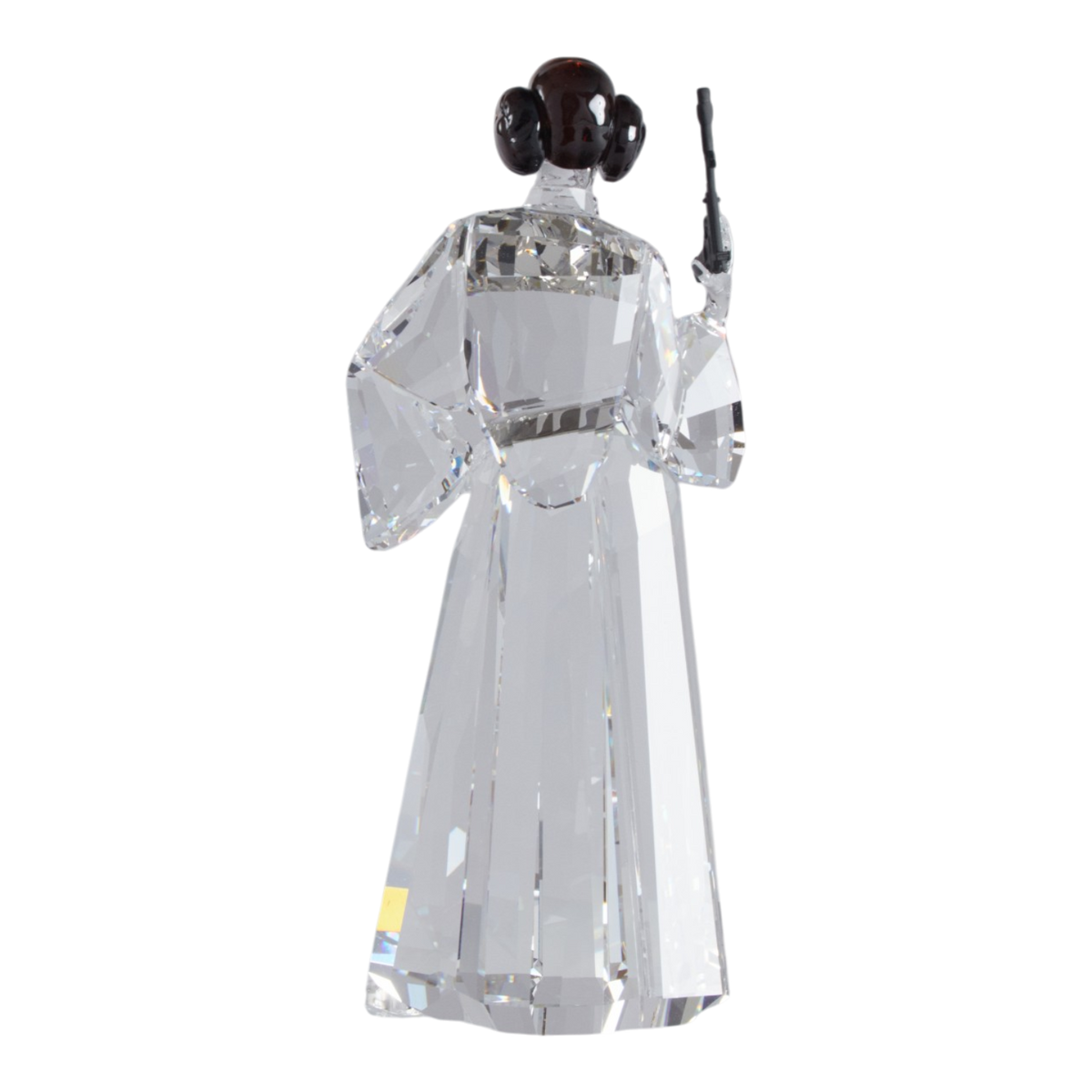 A clear faceted Swarovski crystal figurine of Princess Leia holding a black lacquered metal gun, standing on a transparent base against a plain white background.