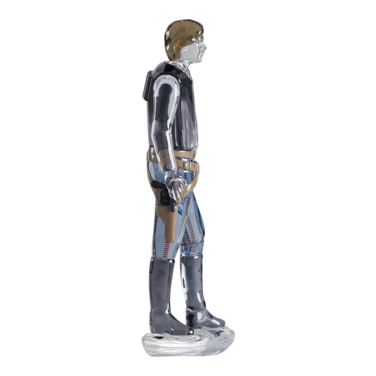 A clear faceted Swarovski crystal figurine of Hans Solo standing on a transparent base against a plain white background.