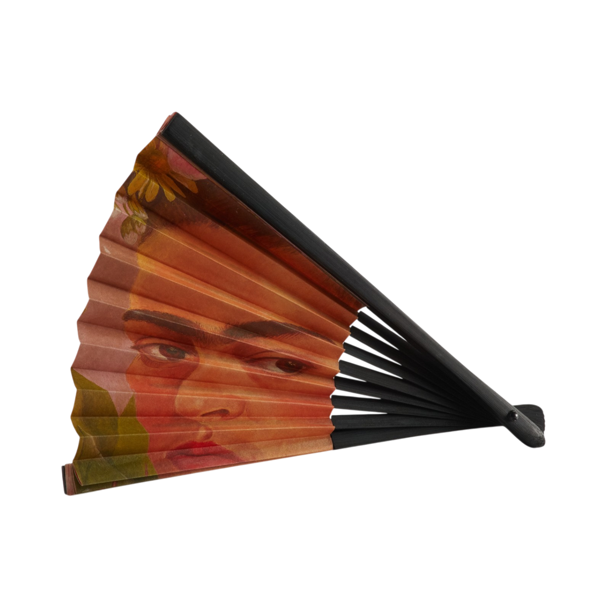 A folding hand fan with a black frame and ribs, featuring a printed design of Frida Kahlo's face in warm earthy tones of orange, brown, and red, with a small yellow flower accent near the top.