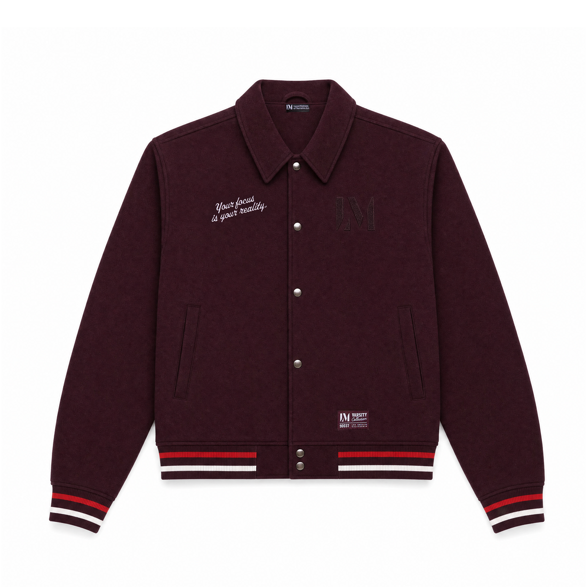 A dark burgundy varsity jacket with white script embroidery on the left chest that says. "Your Focus Is Your Reality," a tonal black 'Lucas Museum of Narrative Art' logo on the right chest, and striped ribbed cuffs and hem in white, red, and navy.