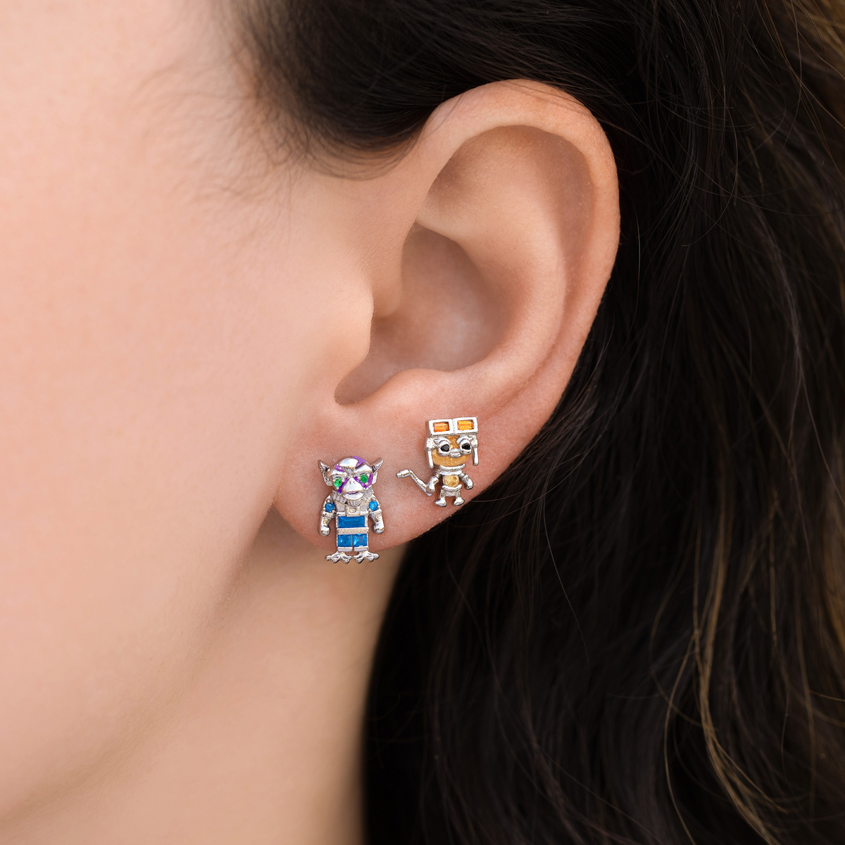 Galactic Crew Silver Stud Set featuring a droid-inspired stud and a creature-inspired character stud with colorful crystal accents, photographed a model's ear.