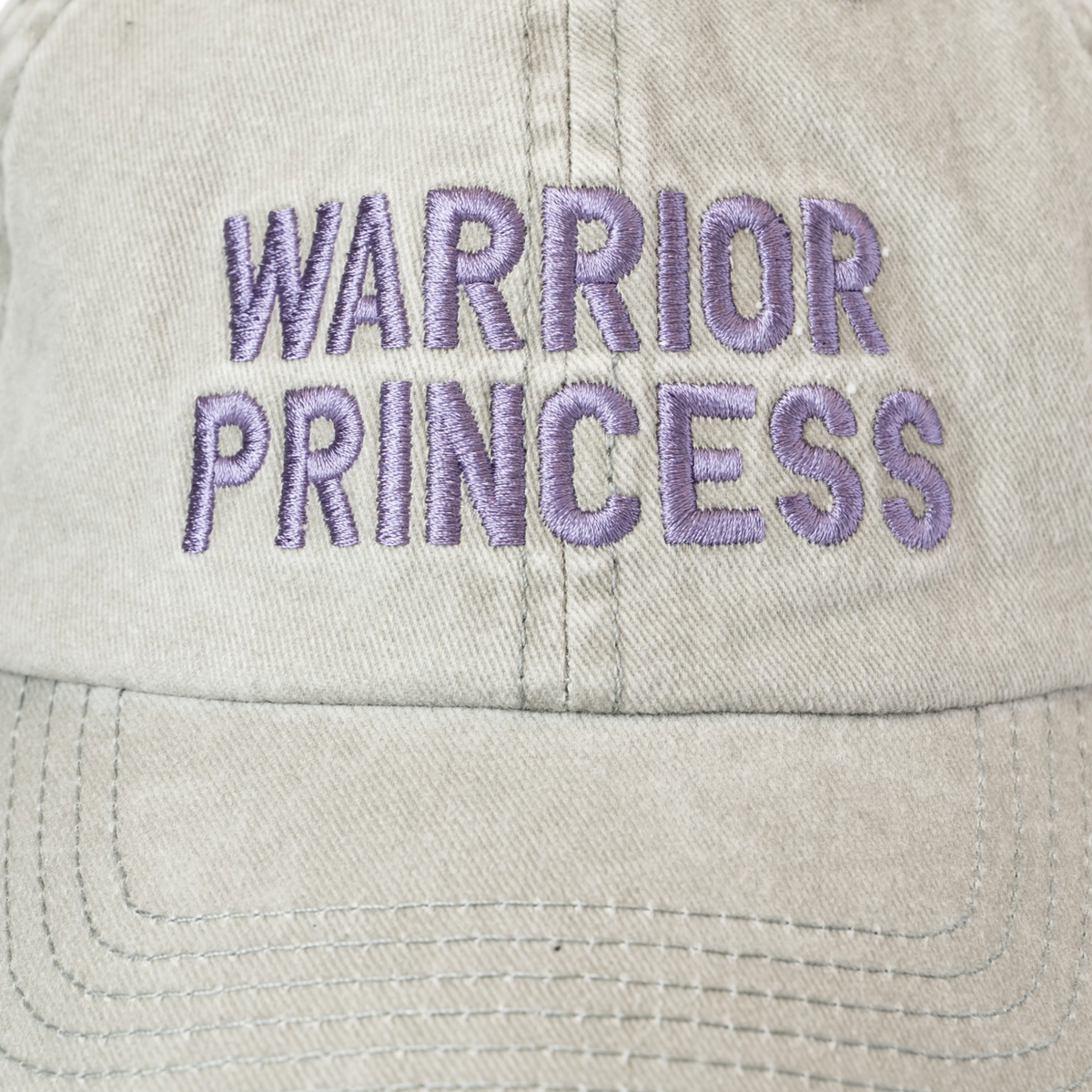 Light gray washed cotton baseball cap featuring “Warrior Princess” embroidered in purple on the front, shown against a white background.