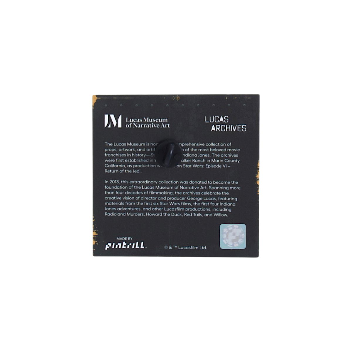A black rectangular Lucas Museum of Narrative Art archive product tag printed white text, a small black handle, and a small blue reflective sticker, photographed on a plain white background.