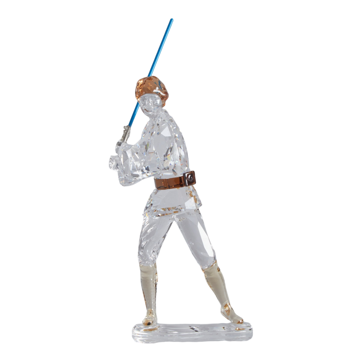 A clear faceted Swarovski crystal figurine of Luke Skywalker holding a blue sword, standing on a transparent base against a plain white background.