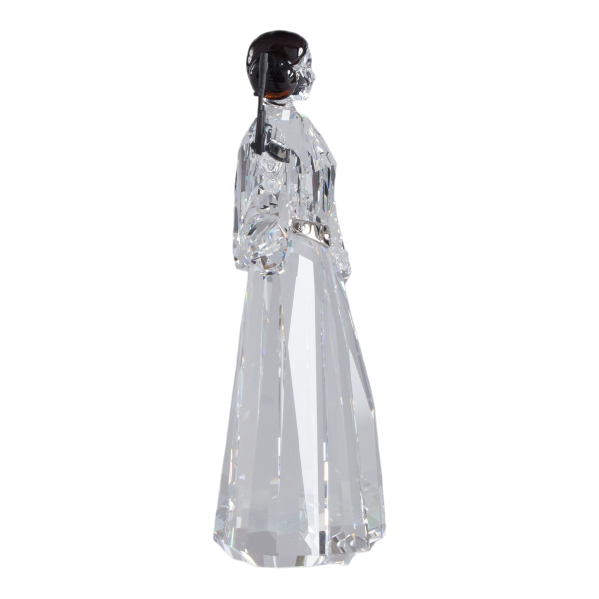A clear faceted Swarovski crystal figurine of Princess Leia holding a black lacquered metal gun, standing on a transparent base against a plain white background.