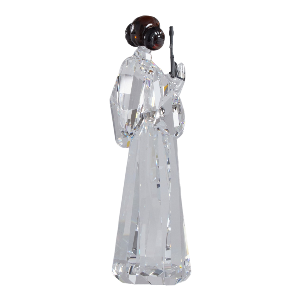 A clear faceted Swarovski crystal figurine of Princess Leia holding a black lacquered metal gun, standing on a transparent base against a plain white background.