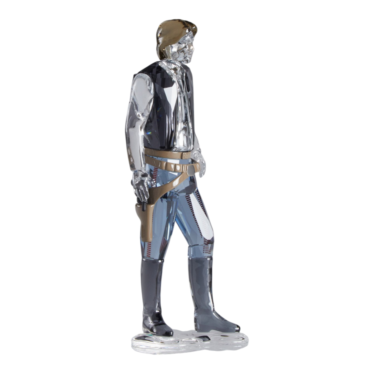 A clear faceted Swarovski crystal figurine of Hans Solo standing on a transparent base against a plain white background.