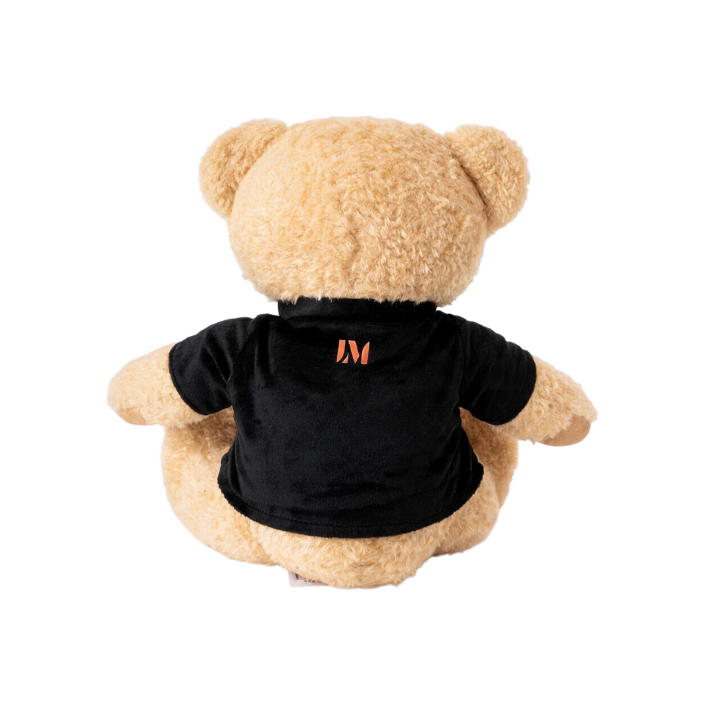 Light tan plush teddy bear wearing a black short-sleeve T-shirt featuring an orange Lucas Museum of Narrative Art logo printed on the back, shown against a white background.