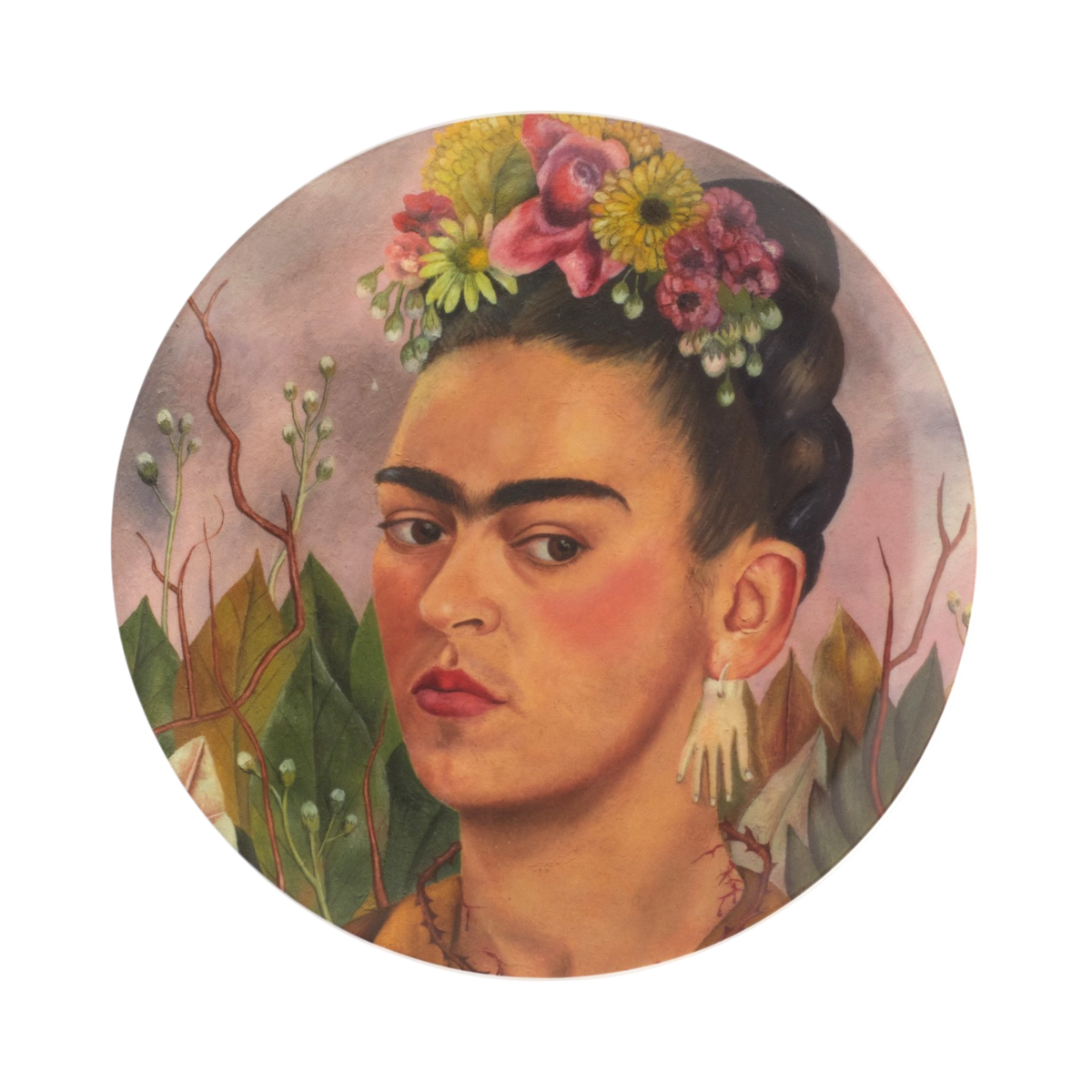 A circular plate featuring a stylized portrait of Frida Kahlo with dark hair adorned with colorful flowers, pink blushed cheeks, and a floral background, centered on a white backdrop.