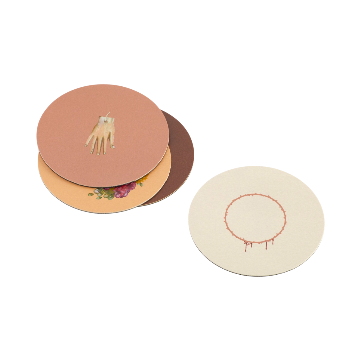 Three round printed coasters or placemats arranged on a light gray background. One coaster is open to show layered designs: a peach top with a beige hand illustration, a tan middle with a floral print, and a dark brown base.
