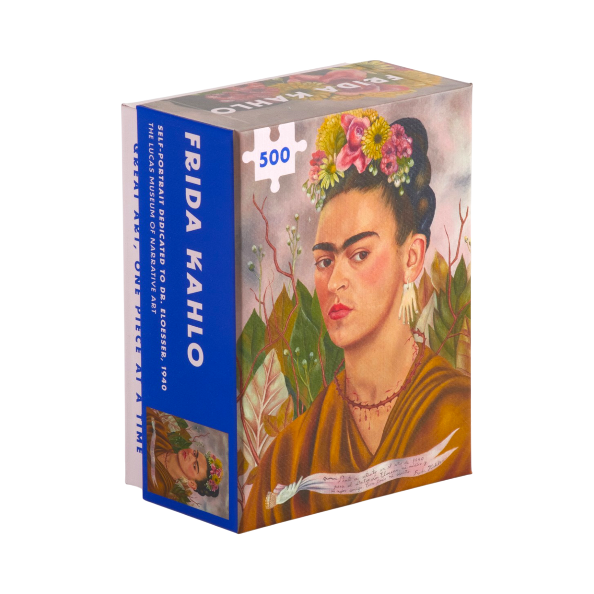 A 500-piece jigsaw puzzle box featuring Frida Kahlo's iconic portrait. The box has a vibrant blue spine and side panel with white text, and the front cover displays a colorful illustration of Frida with flowers in her hair, wearing a brown dress against a soft pink and green background.