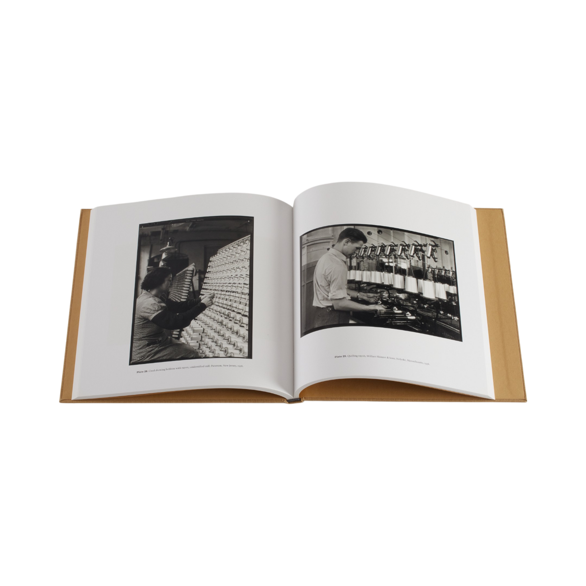 An open hardcover book displayed against a solid white background, showing two black-and-white historical photographs printed on the pages.
